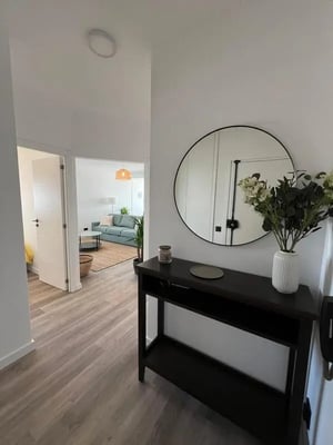 Hallway with console table mirror plants and living room at Lovely 2-bedroom apartment near Praia da Arrifana in Aljezur Student Accommodation