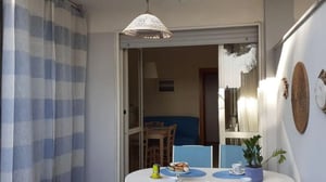 Table chairs with food and plant living room at 1-Bedroom apartment in sunny San Cataldo in Lecce Student Accommodation