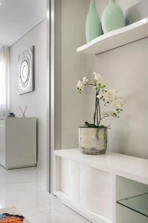 White orchid plant white cabinet white shelf vases hall at Modern flat in Vilamoura near the beach and marina in Vilamoura Student Accommodation