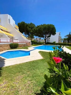 Swimming pools and grassy area exterior at Brilliant 2 Bedroom Apartment with a balcony close to Vilamoura Golf Course in Quarteira Student Accommodation