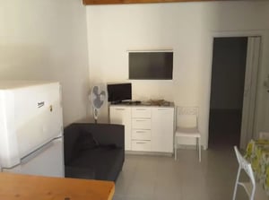 Fridge sofa fan cabinet TV living room at Comfy Apartment close to the beach and the Giuseppe Manno garden in Alghero Student Accommodation