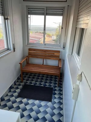 Wooden bench black mat patterned floor exterior at Well-presented bedroom in Portalegre Student Accommodation