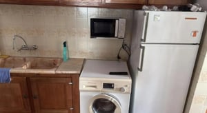 Sink washing machine microwave and refrigerator kitchen at Nice bedroom near Escola de Hotelaria e Turismo in Portalegre Student Accommodation
