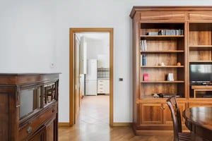 Bookshelf chair and kitchen area living room at Splendid 2-bedroom apartment in Monti in Rome Student Accommodation