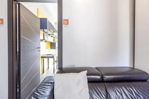 Black leather sofa with white pillow living room at Nice single bdroom in the centre of Sassari in Sassari Student Accommodation