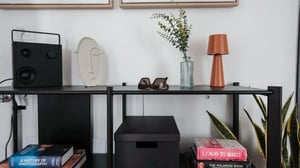 Shelf decor black speaker face vase sunglasses plant lamp bookshelf living room at Comfortable 1-bedroom apartment near the Porto Verde Beach in Monopoli Student Accommodation