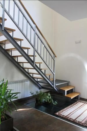 Modern staircase with wooden steps plants and rug Interior at Historic 5 Bedroom House close to Sabor River in Bragança Student Accommodation