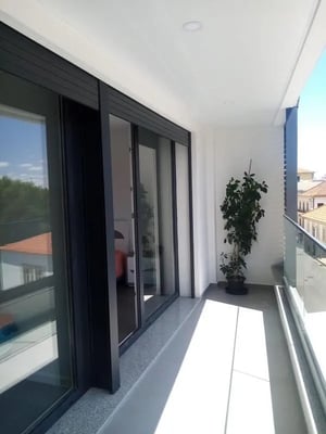 Balcony with glass railing plant and sliding doors Balcony at Welcoming 2 Bedroom apartment close to Polytechnic Institute of Bragança - Agricultural School in Bragança Student Accommodation