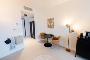 Small table with chairs kitchen counter and lamp living room at Lovely studio in well-connected Katendrecht in Rotterdam Student Accommodation