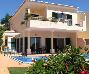 House with pool lounge chairs and balcony exterior at Fascinating 3 Bedroom House with a private Swimming Pool close to Luz Beach in Lagos Student Accommodation