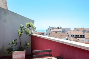 Potted plant and bench on balcony overlooking rooftops exterior at One-bedroom flat with an outdoor balcony, in the centre of Ericeira in Ericeira Student Accommodation