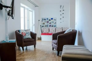 Two brown armchairs a bench a TV living room at Two-bedroom flat with outdoor space in the centre of the village in Ericeira Student Accommodation