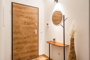Wooden door round mirror plant and vase hallway at Large and bright 3-bedroom flat in Ponte de Sor in Ponte De Sor Student Accommodation