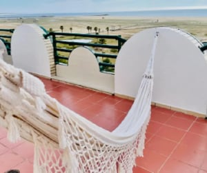 Hammock on tiled balcony with ocean view exterior at Astonishing 3 Bedroom Apartment with a balcony close to Claridade Beach in Figueira Da Foz Student Accommodation