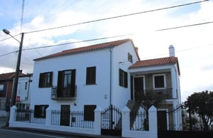 White house with dark shutters and fence exterior at Cozy 2 Bedroom House close to Serra da Estrela in Covilha Student Accommodation