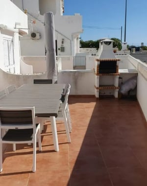 Dining table and barbecue exterior at Exclusive 2 Bedroom Apartment with a terrace close to  Vale de Centeanes Beach in Carvoeiro Student Accommodation