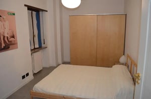 Bed wardrobe and poster bedroom at Spacious 2-bedroom apartment close to Porta Palatina in Turin Student Accommodation