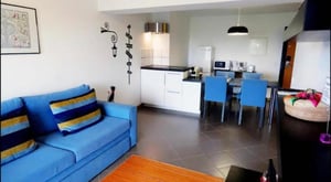 Blue sofa with striped pillows kitchen area living room at Charming 1-bedroom flat in Portimão in Portimão Student Accommodation