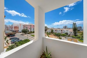 Balcony view pink buildings and parked cars exterior at Comfy bedroom in the serene Vila Rosa neighbourhood in Portimão Student Accommodation