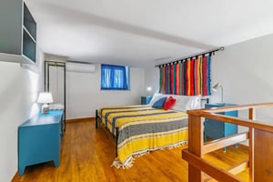 Bed dresser shelves colorful tapestry bedroom at Alluring 1-bedroom apartment in Oreto-Perez in Palermo Student Accommodation