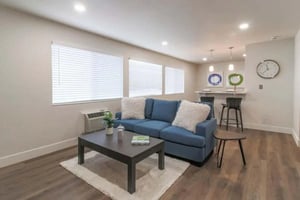 Blue couch with white pillows coffee table bar living room at Aero Apartments in Davis Student Accommodation