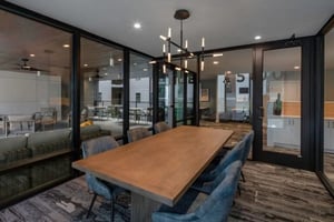 Wood table and chairs with modern chandelier common area at Noble 2500 in Austin Student Accommodation
