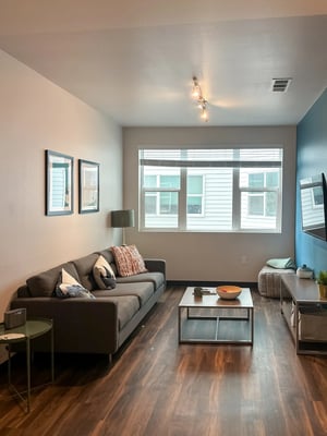 Sofa coffee table artwork window and TV living room at Fifteen51 in Reno Student Accommodation