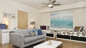 Sofa, beds, desk, wave art living room at ICON in Goleta Student Accommodation