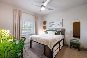 Bed with storage drawers green accents arched mirror bedroom at The Reef Student Living in Fort Myers Student Accommodation