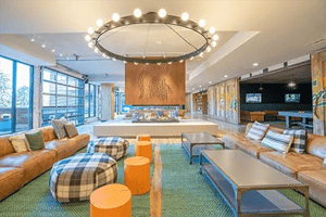 Brown sofas fireplace modern chandelier living room at Landmark on Grand River in East Lansing Student Accommodation