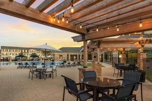 Pergola with string lights lounge chairs pool and buildings exterior at Copper Beech at San Marcos in San Marcos Student Accommodation