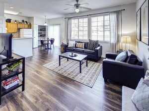 Dark sofas coffee table dining area kitchen living room at Bishops Square in San Marcos Student Accommodation