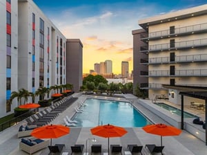 Pool lounge chairs umbrellas buildings city skyline exterior at Apella on Newport in Tampa Student Accommodation