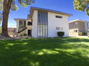 White building with stairs and green lawn exterior at Legacy LV in Las Vegas Student Accommodation