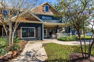 Exterior of building entrance with dark siding and stone accents at The Reserve at College Station in College Station Student Accommodation