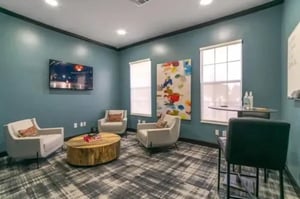 Three armchairs coffee table and television living room at Arden Villas in Orlando Student Accommodation