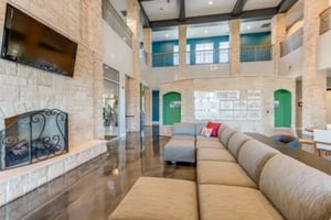 Large sectional sofa television fireplace living room at Campus Village Apartments in College Station Student Accommodation