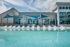 Pool lounge chairs blue shades modern building exterior at Magnolia, A Prosper Community in Tuscaloosa Student Accommodation
