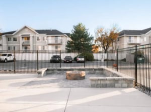 Apartment buildings cars and fire pit area exterior at Village on the Parkway in Orem Student Accommodation