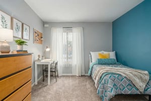 Bed desk lamp dresser plant art and desk bedroom at Campus Hill Apartments