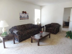 Sofa coffee table lamps armchair living room at Baylor Arms in Waco Student Accommodation