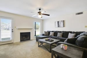 Dark sectional sofa fireplace and coffee table living room at Beau Chene Condominiums, Inc in Baton Rouge Student Accommodation