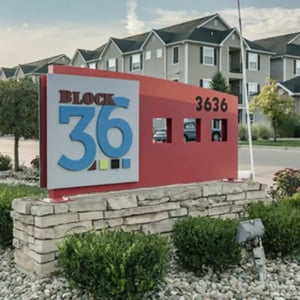 Block 36 sign with apartment buildings exterior at Block 36 - Lease by Bed Available in East Lansing Student Accommodation