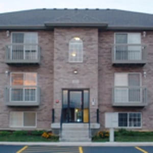 Brick building balconies windows stairs exterior at Aspen Court Apartments in Macomb Student Accommodation