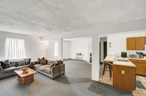 Two sofas coffee table floor lamp living room kitchen at Cedar Lofts East Apartments in State College Student Accommodation