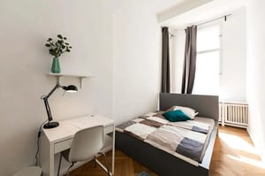 White desk lamp plant vase chair bed bedroom at Room in Grunewaldstraße, 10825 Berlin, Germany in Berlin Student Accommodation