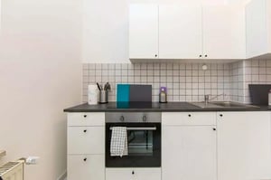 White cabinets oven sink and tile kitchen at Room in Petersburger Str., 10247 Berlin, Germany in Berlin Student Accommodation