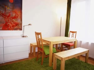 Wooden table and chairs with green rug dining area at Studio in Halenseestraße, 10711 Berlin-Bezirk Charlottenburg-Wilmersdorf, Germany in Berlin Student Accommodation