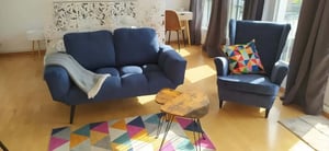 Blue sofa armchair colourful rug and tables living room at Studio in Neue Hochstraße 54, 13347 Berlin, Deutschland in Berlin Student Accommodation