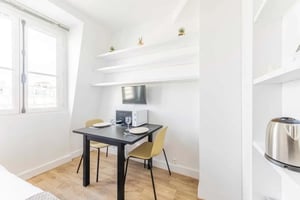 Table chairs microwave TV shelves study area at Studio in 11 Rue Bayard, 75008 Paris, France in Paris Student Accommodation